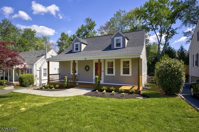 cape cod home featuring a porch, a front yard, and a shingled roof