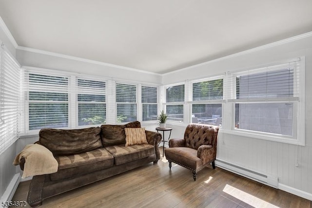 living area featuring a baseboard heating unit, wood finished floors, and crown molding