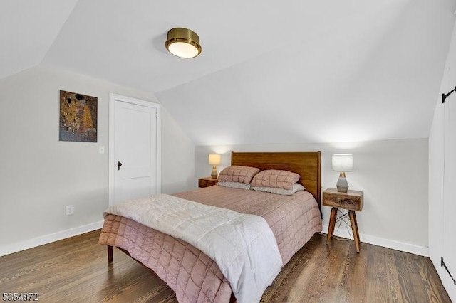bedroom with vaulted ceiling, wood finished floors, and baseboards