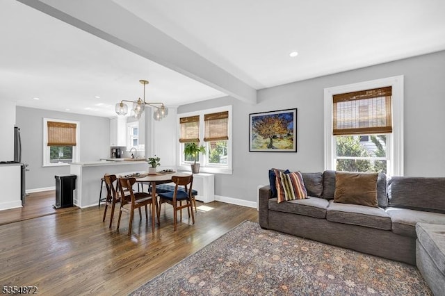 living room featuring healthy amount of natural light, dark wood-style flooring, a chandelier, baseboards, and recessed lighting
