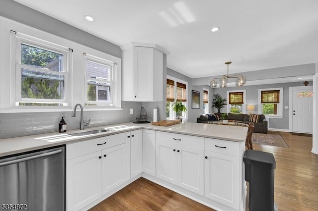 kitchen featuring dishwasher, a peninsula, a chandelier, decorative backsplash, and recessed lighting