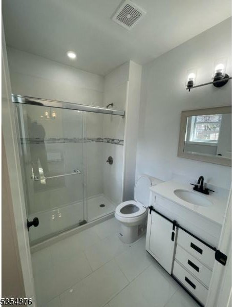 bathroom with vanity, toilet, tile patterned floors, a shower stall, and visible vents
