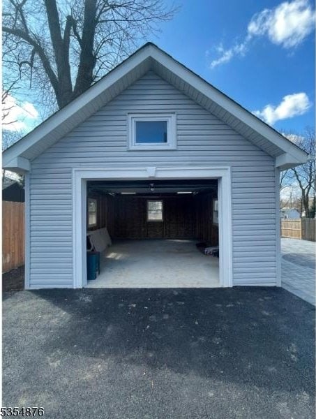 detached garage with aphalt driveway and fence