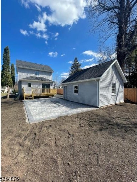 rear view of house featuring a patio, fence, and a wooden deck