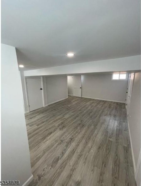 basement with baseboards and wood finished floors