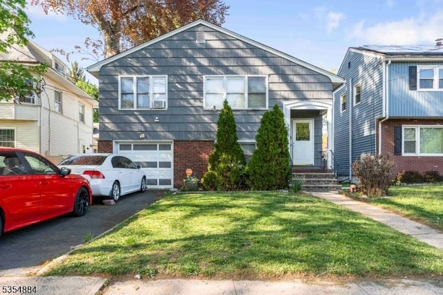 view of front of home featuring brick siding, a garage, a front lawn, and aphalt driveway