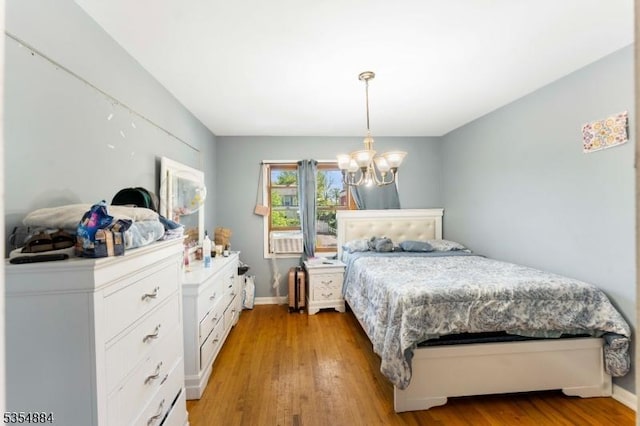bedroom with light wood-style floors, baseboards, and a notable chandelier