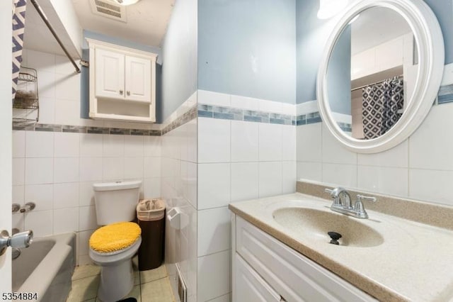 bathroom featuring vanity, toilet, tile walls, curtained shower, and visible vents