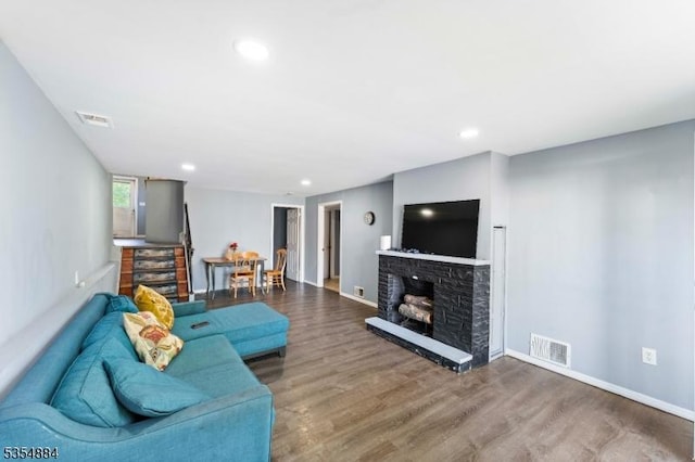 living area with baseboards, wood finished floors, and visible vents