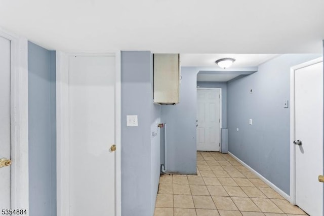 laundry room with baseboards and light tile patterned floors
