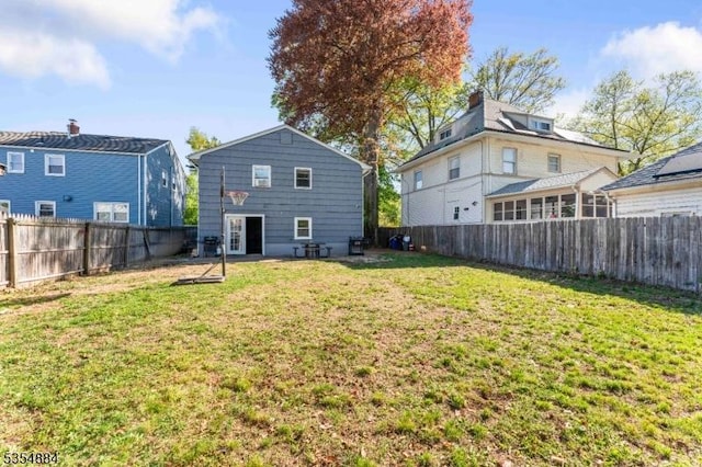 back of property with a yard and a fenced backyard