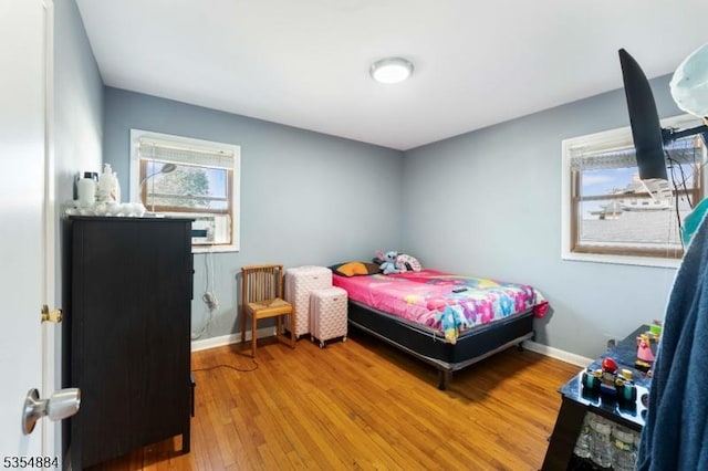bedroom with baseboards, wood finished floors, and radiator