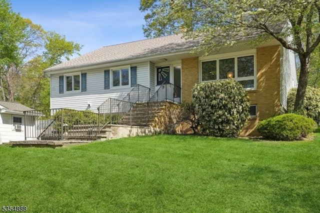 ranch-style home featuring a front lawn and brick siding