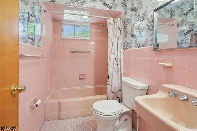 full bath with a sink, a wainscoted wall, toilet, shower / bath combo with shower curtain, and wallpapered walls