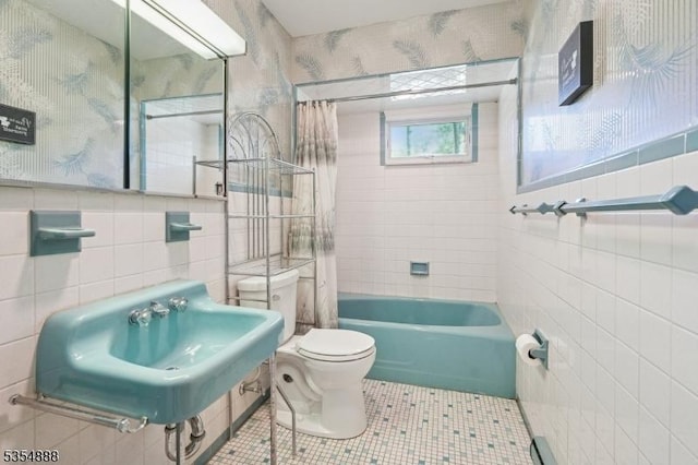 bathroom featuring toilet, tile walls, wallpapered walls, tile patterned floors, and a sink