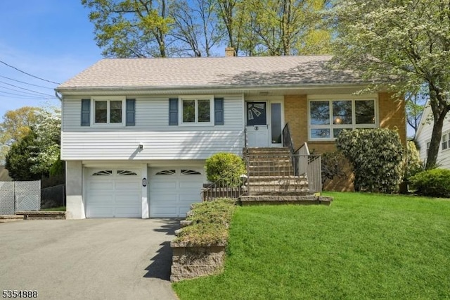 ranch-style home with an attached garage, a front lawn, entry steps, and aphalt driveway