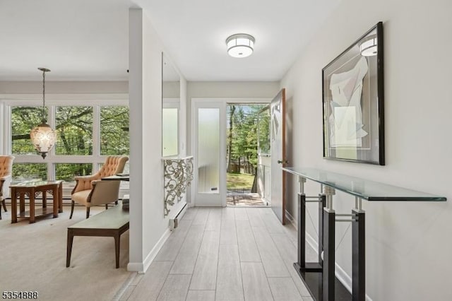 doorway with light wood-style floors and baseboards
