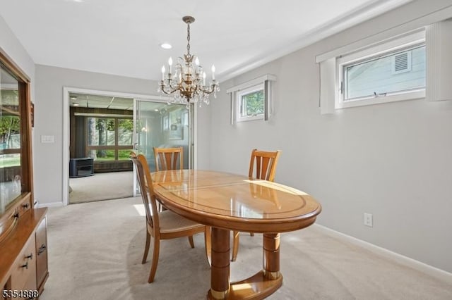 dining room featuring baseboards, light colored carpet, and a chandelier