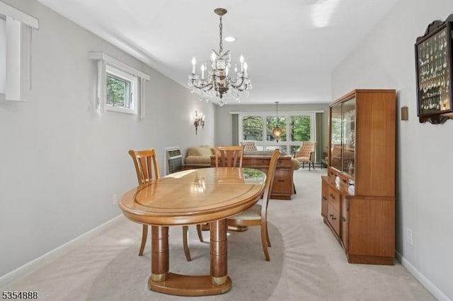 dining room featuring a chandelier, baseboards, light colored carpet, and plenty of natural light