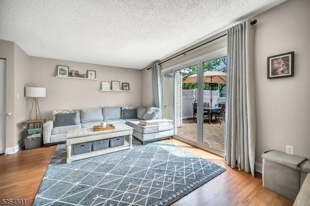 living area with a textured ceiling and wood finished floors