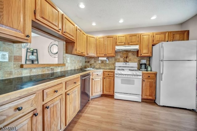 kitchen with a sink, white appliances, recessed lighting, tasteful backsplash, and under cabinet range hood