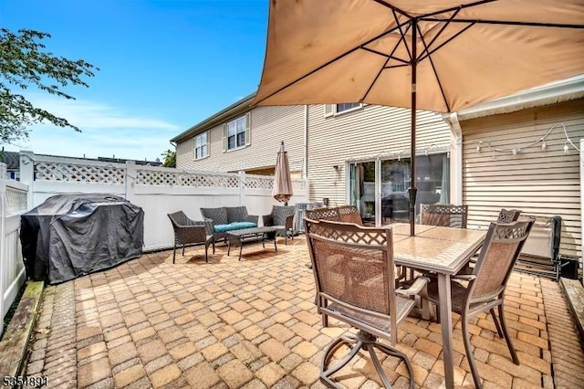 view of patio with grilling area, fence, an outdoor hangout area, and outdoor dining space