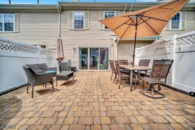 rear view of house featuring a patio, outdoor dining area, and fence