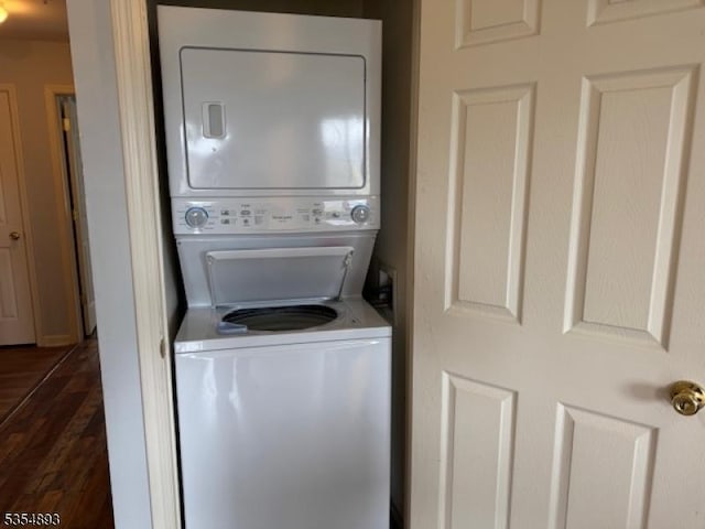 washroom with laundry area, dark wood finished floors, and stacked washing maching and dryer