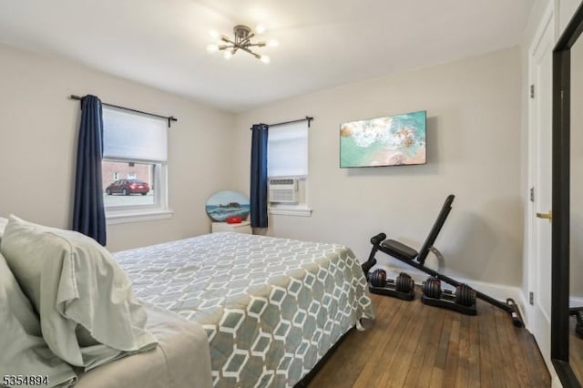 bedroom with baseboards, a notable chandelier, and dark wood-type flooring