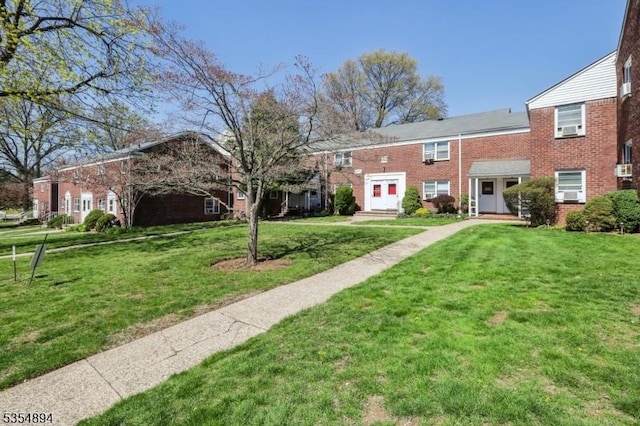 townhome / multi-family property featuring a front lawn and brick siding