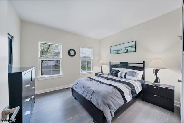 bedroom with baseboards and wood finished floors