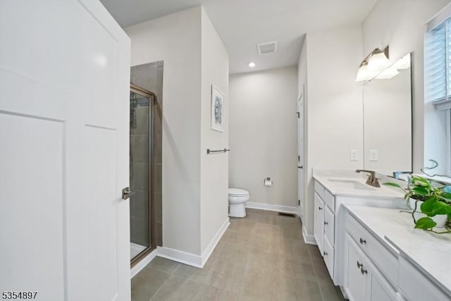 full bathroom with vanity, baseboards, a stall shower, and toilet
