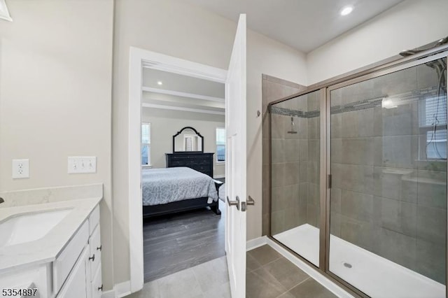 ensuite bathroom with vanity, baseboards, recessed lighting, a shower stall, and ensuite bath