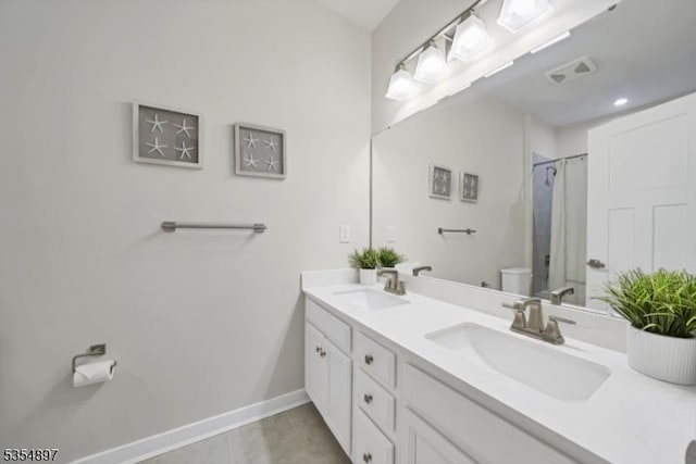 full bath with double vanity, a sink, baseboards, and toilet