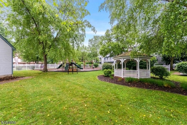 view of yard with a gazebo, fence, and playground community