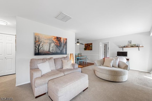 carpeted living area with visible vents, baseboards, and ceiling fan