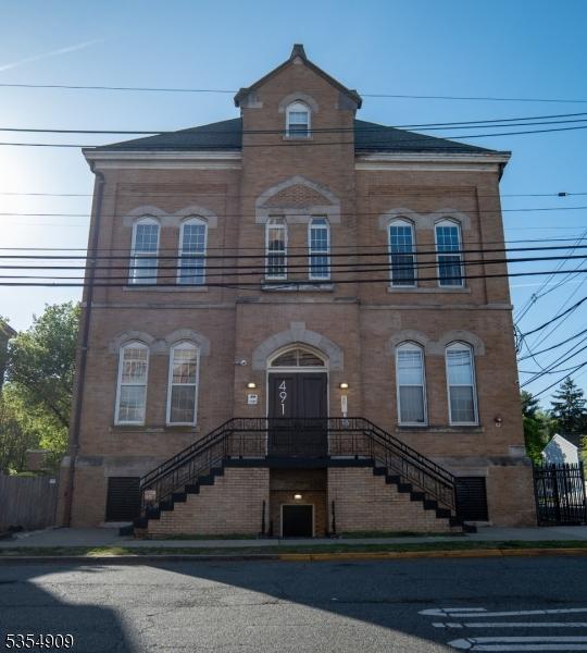 view of front of house featuring fence and brick siding