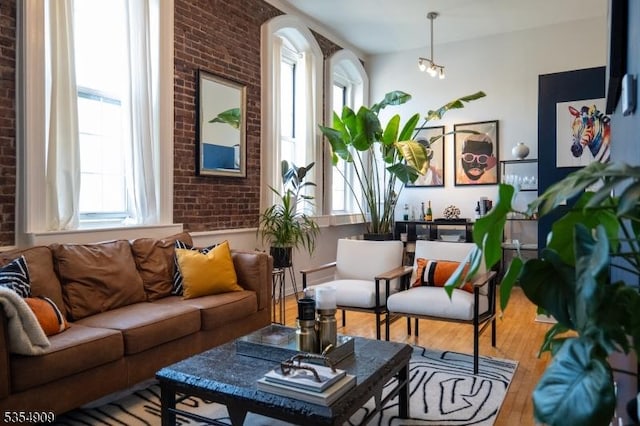 interior space featuring brick wall, a healthy amount of sunlight, and wood finished floors