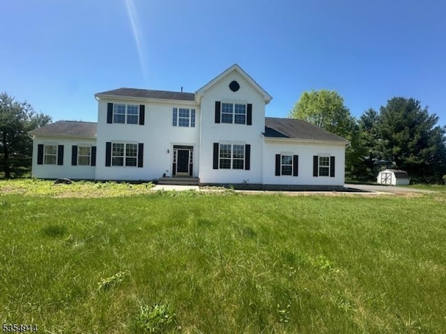 27 Suydam Rd, Franklin Twp, NJ 08873 - view of front of house with a shed, a front yard, an outdoor structure, and stucco siding