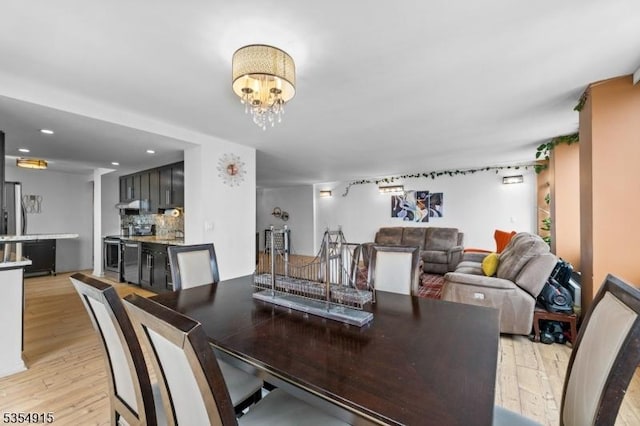 dining space with recessed lighting, a chandelier, and light wood-style floors