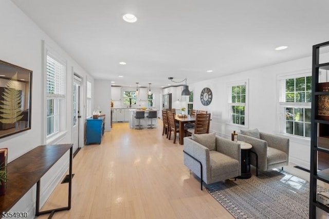living area with light wood finished floors and recessed lighting