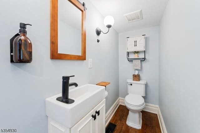 bathroom with wood finished floors, toilet, baseboards, and vanity