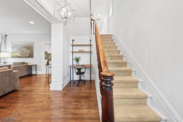 stairs featuring wood finished floors, a chandelier, and recessed lighting