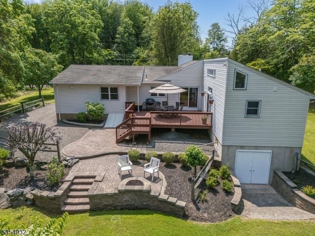 217 Long Hill Rd, Hillsborough Twp, NJ 08844 - back of house with a wooden deck, a patio, a chimney, and a lawn