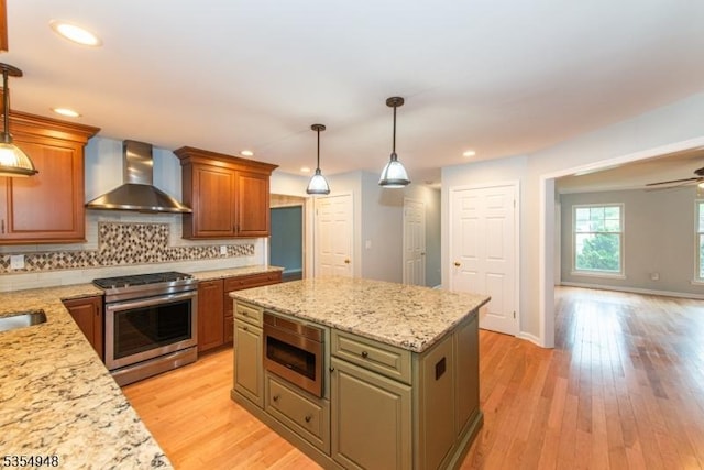 70 Crenshaw Dr, Mount Olive Twp, NJ 07836 - kitchen featuring appliances with stainless steel finishes, wall chimney exhaust hood, backsplash, light wood-style floors, and light stone countertops