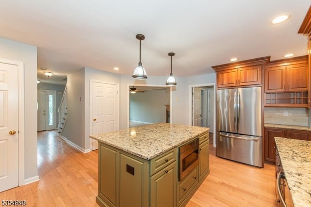70 Crenshaw Dr, Mount Olive Twp, NJ 07836 - kitchen featuring appliances with stainless steel finishes, light wood-type flooring, decorative backsplash, hanging light fixtures, and a kitchen island