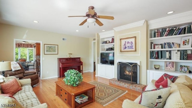 living room featuring a ceiling fan, visible vents, a fireplace, wood finished floors, and recessed lighting