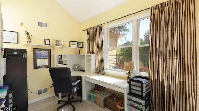 office featuring carpet flooring, visible vents, a healthy amount of sunlight, and lofted ceiling