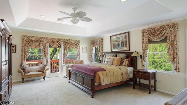 bedroom with access to outside, a raised ceiling, and light carpet