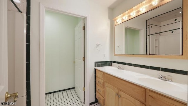 full bathroom featuring double vanity, a sink, and tile patterned floors